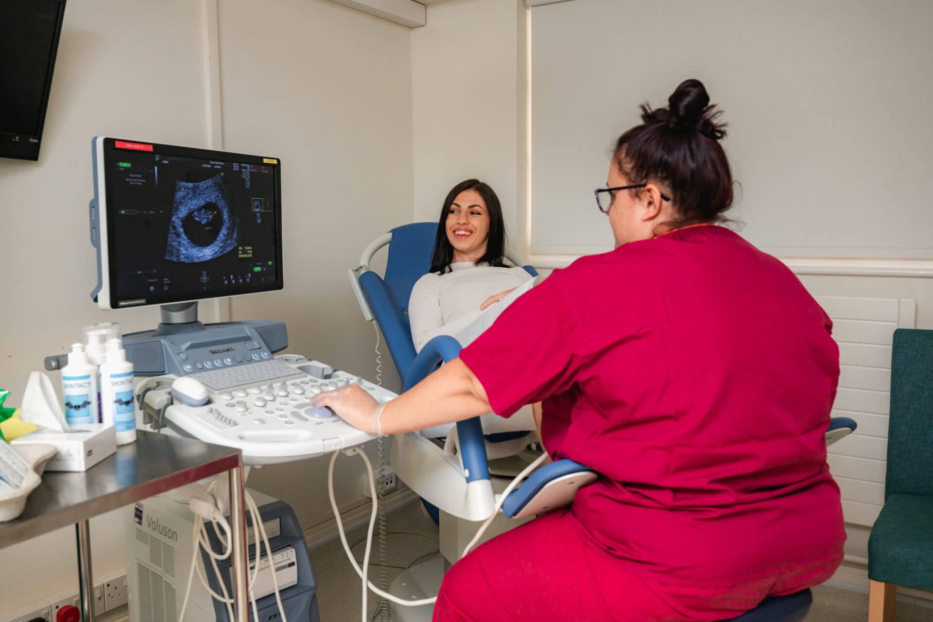 A female radiographer performing an internal transvaginal ultrasound.