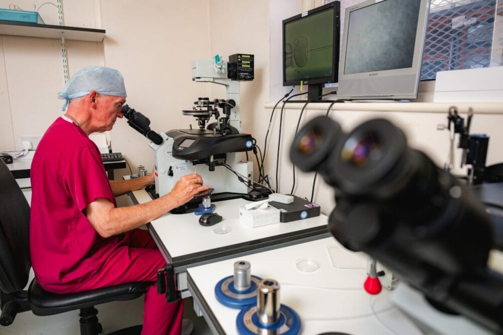 Embryologist working at a microscope in the Bourn Hall Fertility Clinic laboratory