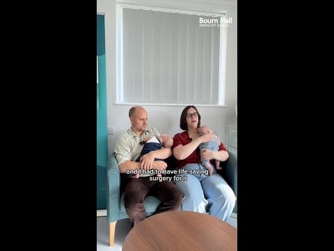 A still from a video of a mother and father holding their babies' and talking about their journey at Bourn Hall.